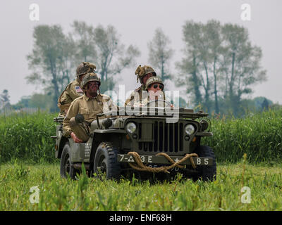 Amerikanische uns alliierte Soldaten in WW2 Uniform sitzt in einem Willys Jeep auf einer Wiese im Rahmen des d-Day-Jahrestag, Normandie Frankreich Stockfoto