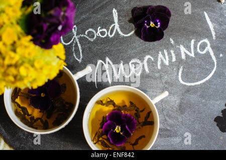 Tasse o Tee und Frühling Blumen mit beachten Sie guten Morgen Stockfoto