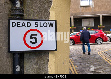 Langsam Zeichen auf eine schmale Straße auf der Hauptstraße in South Queensferry, in der Nähe von Edinburgh, Scotland, UK. Stockfoto