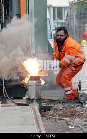 Merseburg, Deutschland. 30. April 2015. Ein Techniker schweißt zwei Straßenbahn Spur Komponenten zusammen mit einer Thermit-Reaktion in Merseburg, Deutschland, 30. April 2015. Das international agierende Unternehmen Goldschmidt Thermit Group öffnet offiziell ihre Forschungs- und Technologiezentrum in Leipzig am Donnerstag, 07. Mai. Foto: Sebastian Willnow/Dpa/Alamy Live News Stockfoto