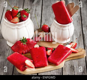 Hausgemachte Erdbeereis knallt - Eis am Stiel - mit frischen reifen Beeren Stockfoto