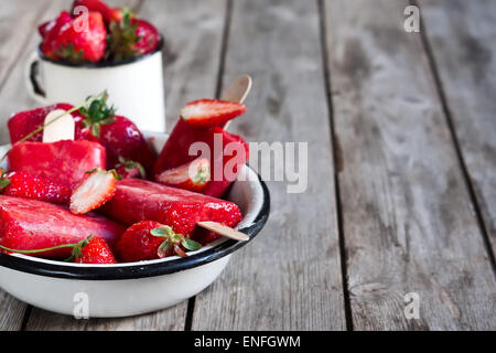 Hausgemachte Erdbeereis knallt - Eis am Stiel - mit frischen reifen Beeren. Kopieren Sie Weltraum Hintergrund. Stockfoto