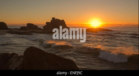 Panorama-Bild der feurigen Sonnenaufgang über den Pazifischen Ozean und schroffen Felsen am Strand in geschützten Bucht bei Nambucca Heads NSW Australia Stockfoto