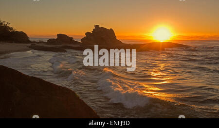 Panorama-Bild der feurigen Sonnenaufgang über den Pazifischen Ozean und schroffen Felsen am Strand in geschützten Bucht bei Nambucca Heads NSW Australia Stockfoto