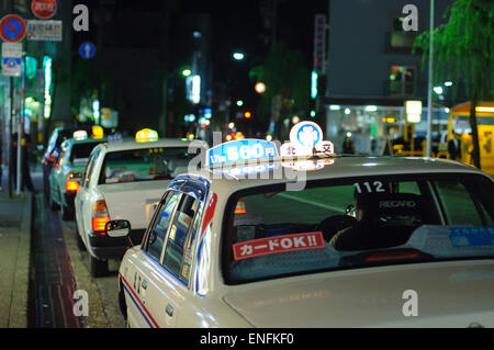 Atmosphäre der Nacht in Japan: Taxis warten für Kunden in einer japanischen Stadt Vergnügungsviertel. Taxistand, japanischen Taxis, Taxi. Stockfoto