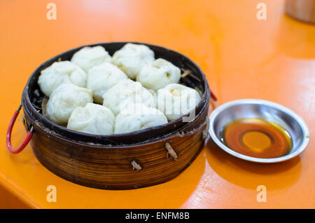 Traditionelle chinesische Dämpfeinsatz mit Dim-Sum-Knödel & Chili-Öl, auf einem Tisch in einem kantonesische Restaurant, Guangzhou (Kanton) Stockfoto