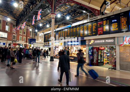 Pendler Passagiere schauen Zug Abfahrtstafel am Bahnhof London Victoria station Stockfoto