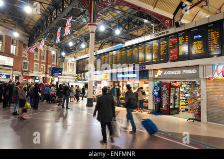 Pendler Passagiere schauen Zug Abfahrtstafel am Bahnhof London Victoria station Stockfoto