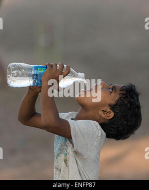 Junge Trinkwasser aus einer Plastikflasche, Fort Cochin, Kochi, Kerala, Indien Stockfoto