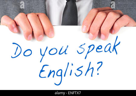 sprechen ein Mann in einem Anzug hält ein Schild mit dem Satz Sie Englisch? darauf geschrieben Stockfoto