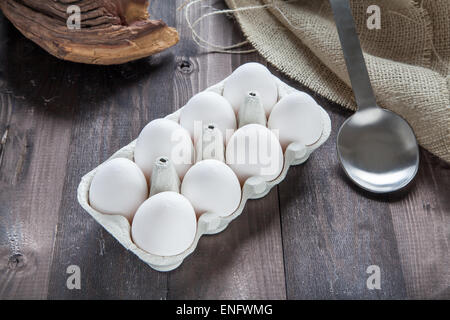 Eiern in einem Eggbox auf einem schwarzen Holztisch Stockfoto