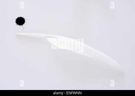 Weiße Feder und Tinte auf weißem Fleck strukturiertem Papierhintergrund Stockfoto