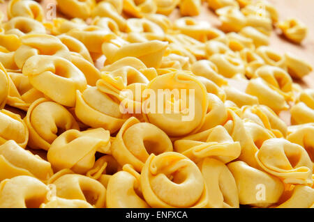 Nahaufnahme von einem Haufen von rohem Tortellini auf einem Holztisch Stockfoto