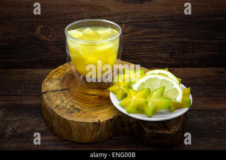 Ananassaft und Zitronensaft mit Sternfrucht auf einem hölzernen Hintergrund. Stockfoto