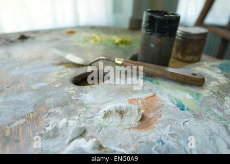 Gemischte Öle weiße Farbe auf große Palette mit Maler Palette Messer und Hauch von Studio im Hintergrund Stockfoto