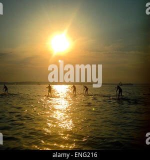 Menschen Paddling unter Sonnenuntergang Himmel Stockfoto