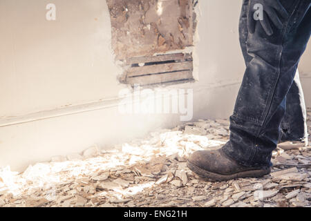 Hispanische Bauarbeiter in Trümmern der Wand stehend Stockfoto