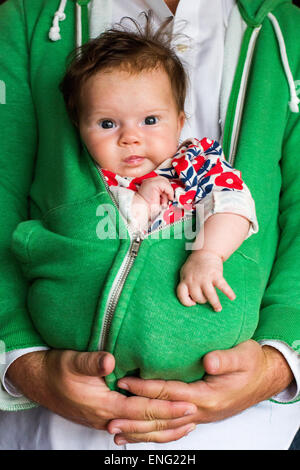 Kaukasische Vater hält Babymädchen in zip hoodie Stockfoto