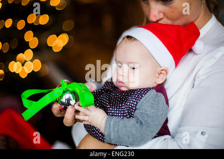 Nahaufnahme von Mutter hält Babymädchen mit Christbaumschmuck Stockfoto