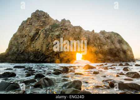 Sonne durch Felsformation, Meereswellen, Big Sur, Kalifornien, USA Stockfoto