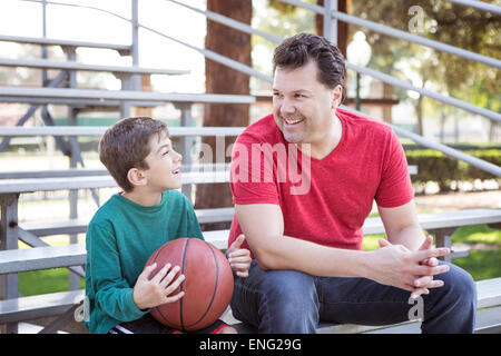 Kaukasische Vater und Sohn sprechen auf Tribüne Stockfoto