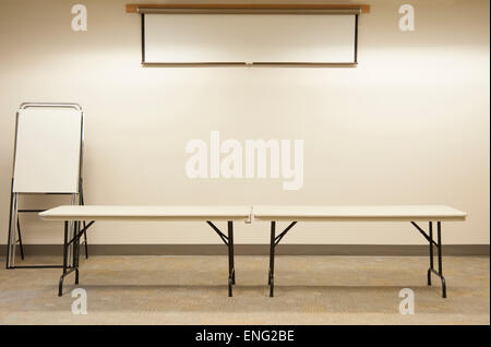 Leere Tabellen unter Leinwand im Klassenzimmer Stockfoto