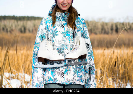 Kaukasische Frau mit Schlittschuhen im Feld Stockfoto