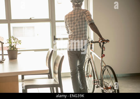 Schwarze Geschäftsmann Ausscheiden aus dem Amt mit dem Fahrrad Stockfoto