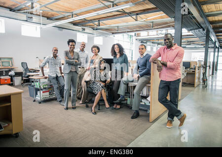 Geschäftsleute, die lächelnd am Schreibtisch im Büro Stockfoto