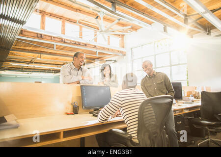 Geschäftsleute, die gemeinsam am Schreibtisch im Büro Stockfoto