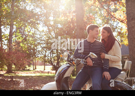 Paar sitzt auf Roller im park Stockfoto