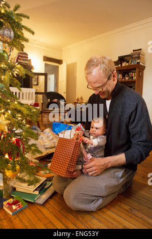 Vater und Baby Boy Eröffnung Weihnachtsgeschenke Stockfoto