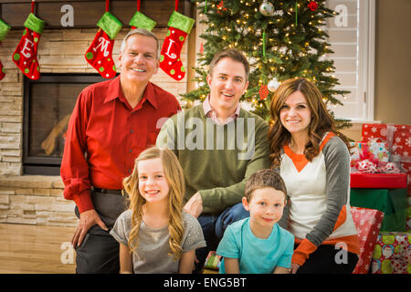 Kaukasische Multi-Generationen-Familie lächelnd im Wohnzimmer an Weihnachten Stockfoto