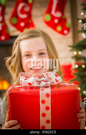 Kaukasische Mädchen halten Weihnachtsgeschenk Stockfoto