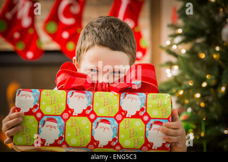 Kaukasische junge hält Weihnachtsgeschenk Stockfoto