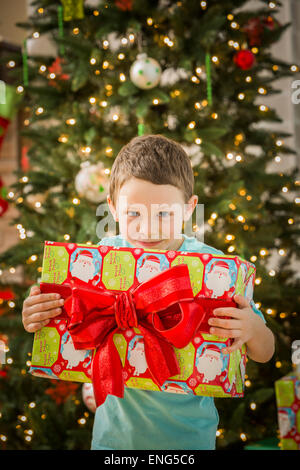 Kaukasische junge hält Weihnachtsgeschenk Stockfoto