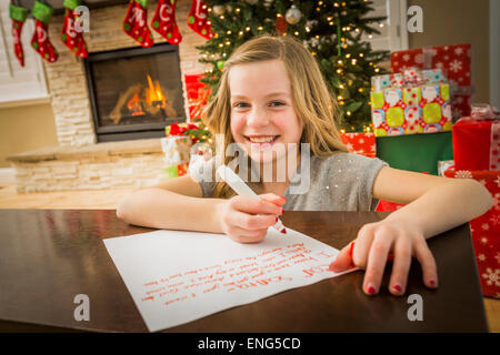 Kaukasische Mädchen schreiben an den Weihnachtsmann zu Weihnachten Stockfoto