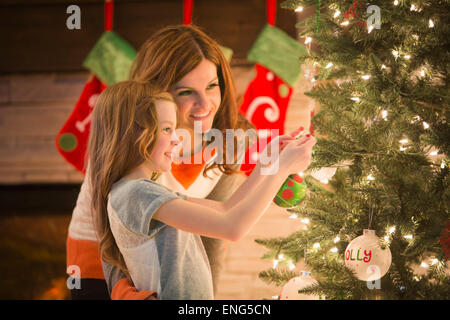 Kaukasische Mutter und Tochter schmücken Weihnachtsbaum Stockfoto