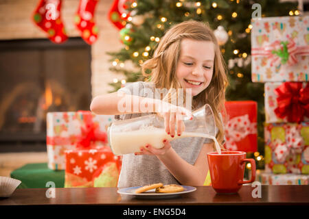 Kaukasische Mädchen verlassen Kekse und Milch für den Weihnachtsmann zu Weihnachten Stockfoto