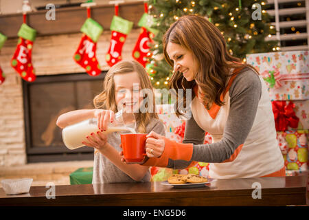 Kaukasische Mutter und Tochter verlassen Kekse und Milch für den Weihnachtsmann zu Weihnachten Stockfoto