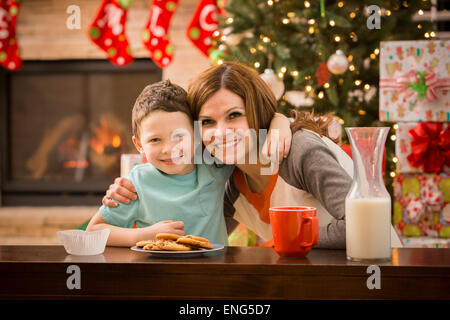 Kaukasische Mutter und Sohn verlassen Kekse und Milch für den Weihnachtsmann zu Weihnachten Stockfoto