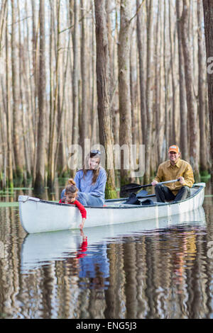 Familie Zusammensitzen im Kanu auf dem Fluss Stockfoto