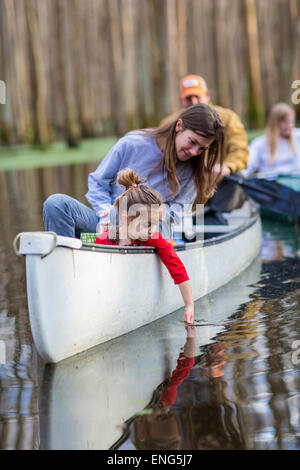 Familie Zusammensitzen im Kanu auf dem Fluss Stockfoto