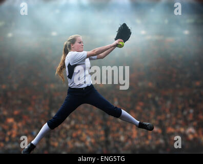 Kaukasische Softball Spieler pitching Kugel im Stadion Stockfoto