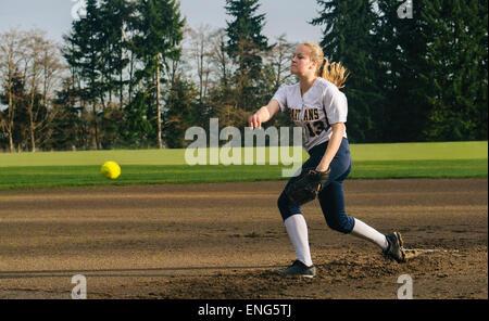 Kaukasische Softball Spieler pitching Ball im Feld Stockfoto