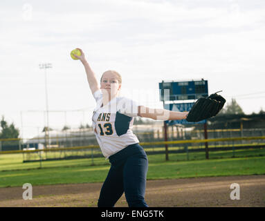 Kaukasische Softball Spieler pitching Ball im Feld Stockfoto