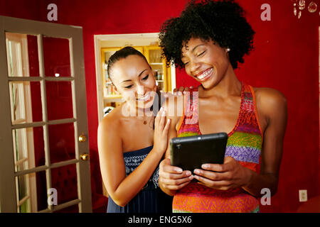 Lächelnde Frauen mit digital-Tablette im Wohnzimmer Stockfoto