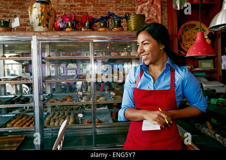 Hispanische Kellnerin Bestellannahme in Bäckerei Stockfoto