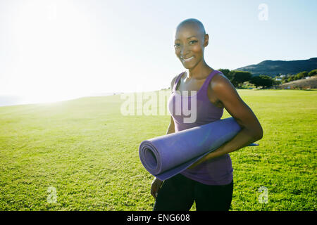 Afrikanische amerikanische Frau, die Yoga-Matte im park Stockfoto