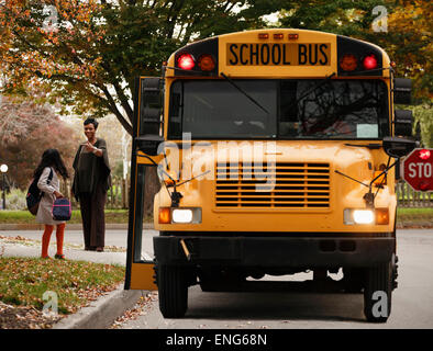 Afroamerikanische Frau wartet mit Tochter für Schulbus Stockfoto